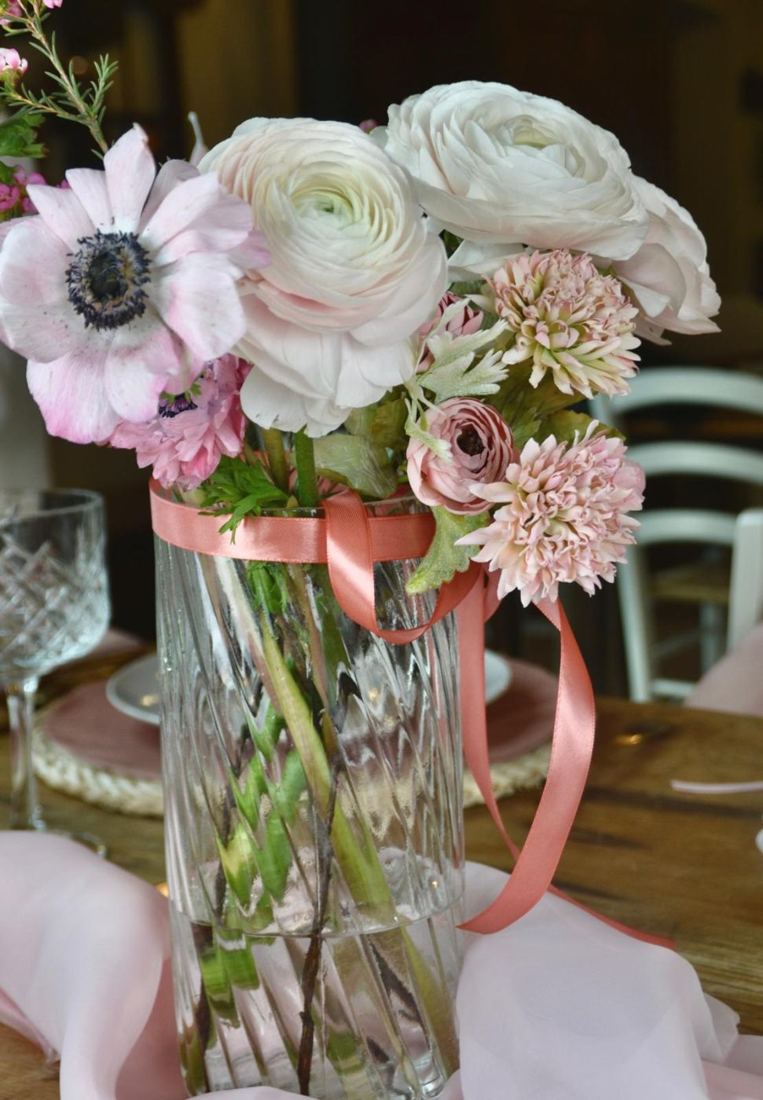 Composizione di anemoni, ranuncoli e rose con nastro rosa