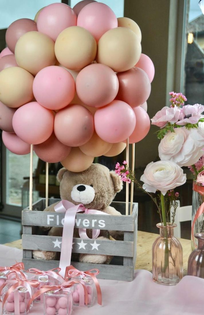 Composizione di palloncini rosa con orsetto e fiori