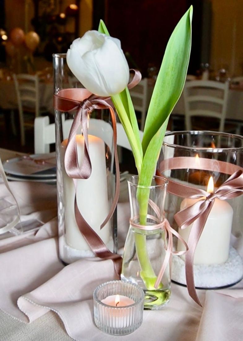Tulipano bianco, candele e nastri su tavola apparecchiata