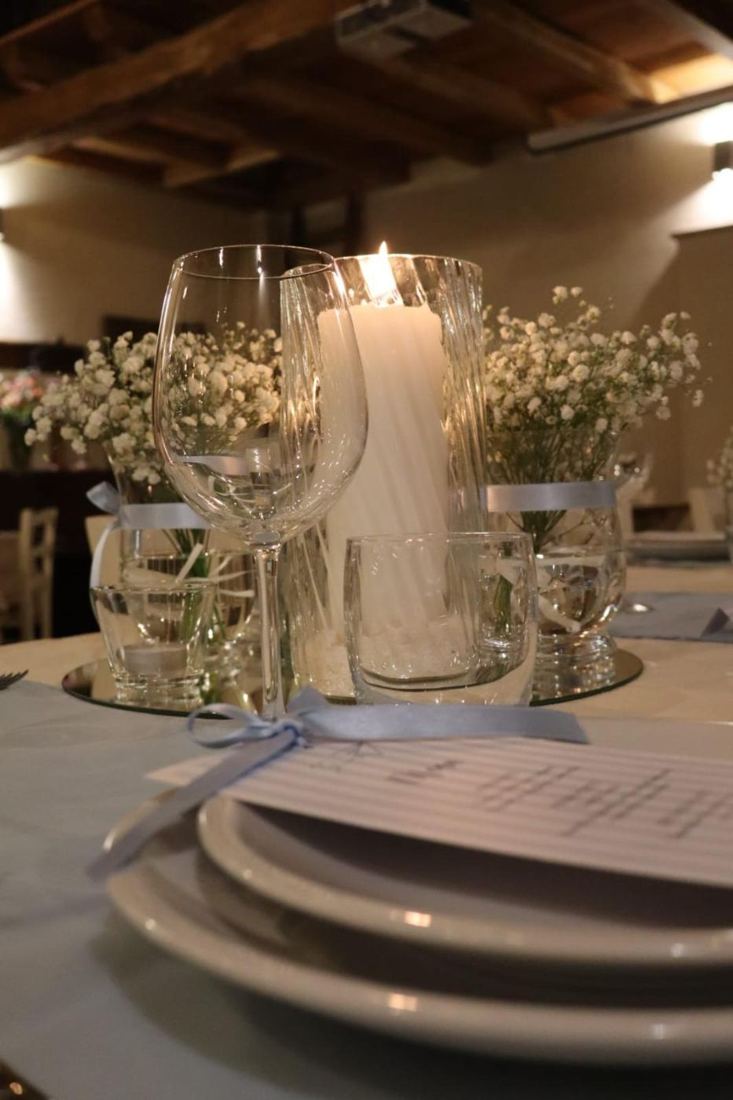 Centrotavola con candele, calici e fiori bianchi