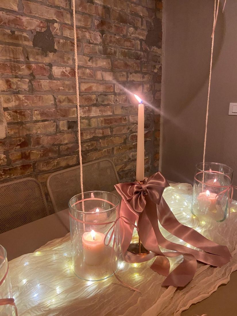 Candela e tulle rosa su tavolo con luci